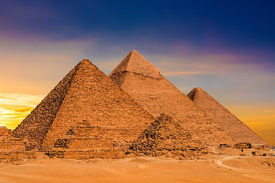 A photo of a group of pyramids against a clear blue sky.