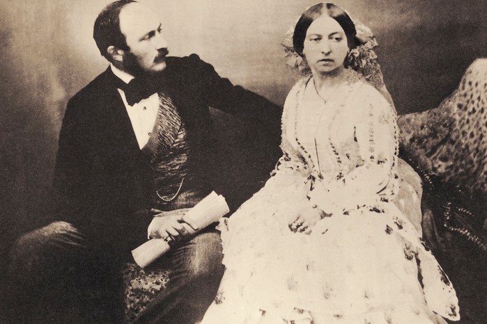 Victoria and Albert in 1854, some 14 years after the queen married her first cousin. By the time this photograph was taken, she had already borne eight of the nine children they would have together (Image by Getty Images) A black and white photograph of Victoria and Albert. He sits on the left, dressed in a black suit and bow tie, with one arm leaning on the back of the seat and the other holding a scroll. Victoria, dressed in a long white dress, sits on the right, looking slightly away from Albert and the camera