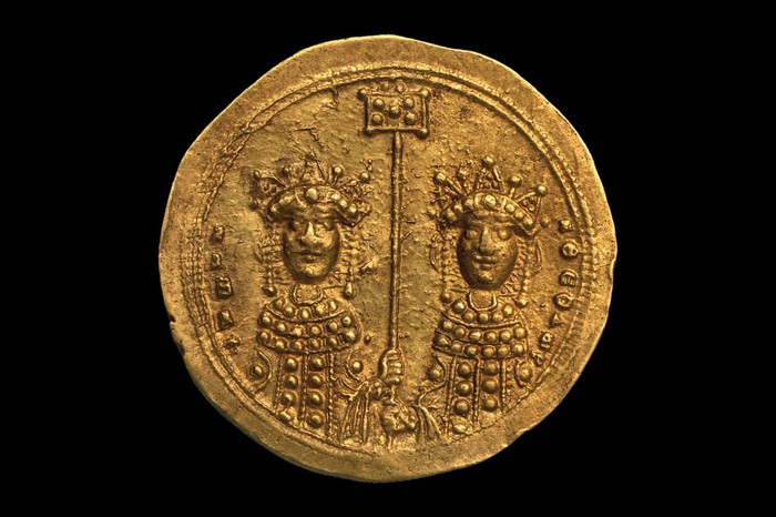 A gold coin with two portraits of queens on it