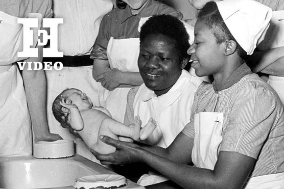 NHS nurses holding a baby.